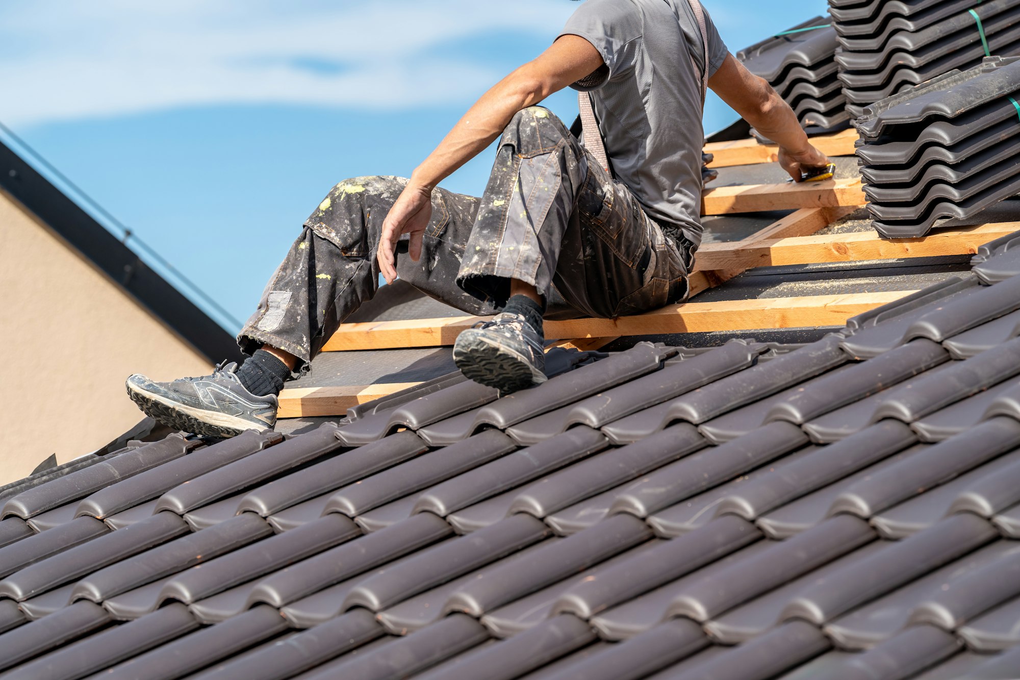 installation of roofing by a craftsman, ceramic tiles on wooden beams