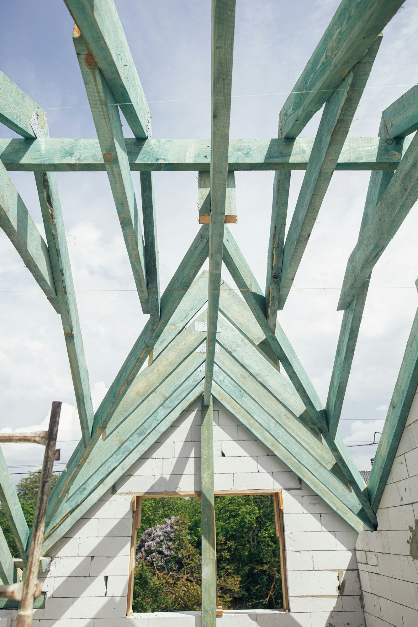 Wooden roof framing. Unfinished roof trusses and block walls, view in attic with rafters and beams